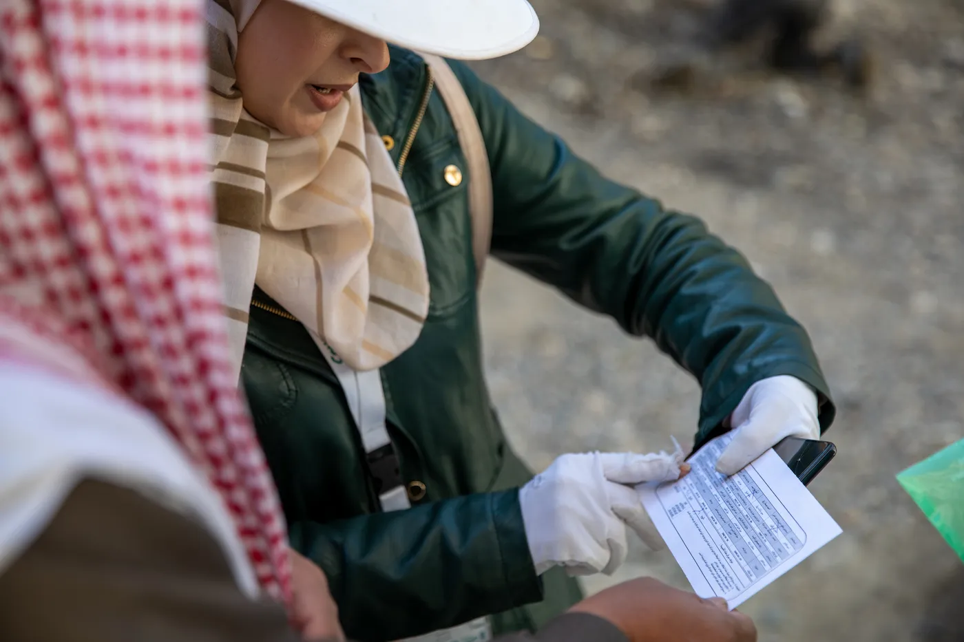 A Concern staff member examining a piece of paper with a table printed on it.